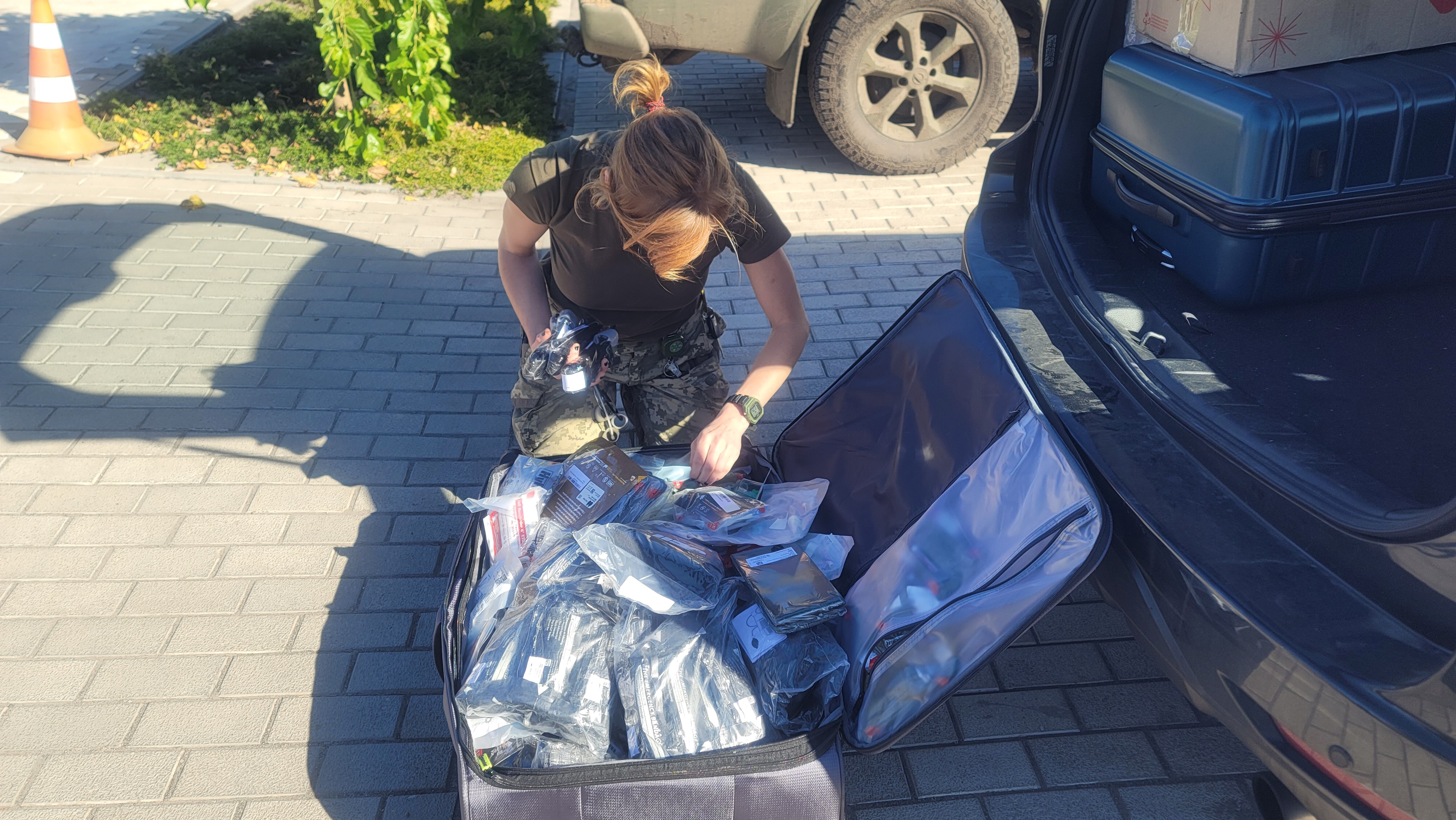 Woman sorting supplies at a car in Ukraine